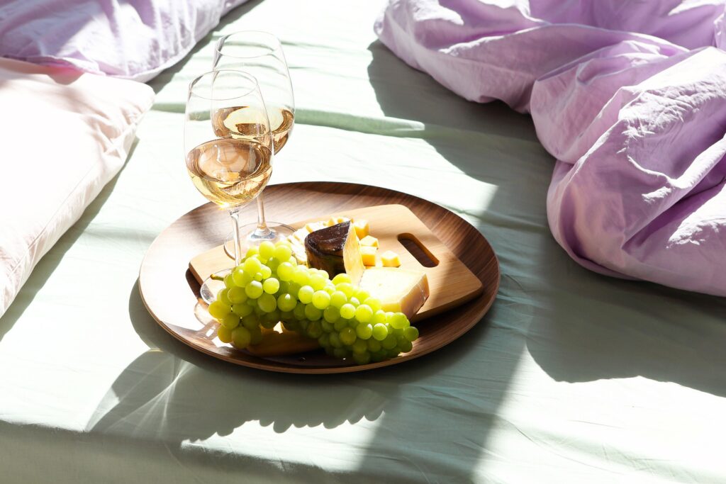 Wine and food on bed in sunny day